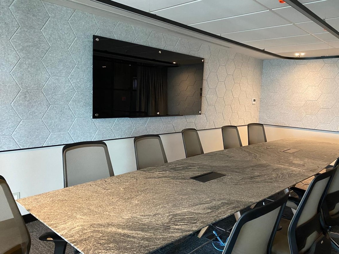 Sala de juntas con panel Reverb a muro, patrón hexagonal, color gris espacial